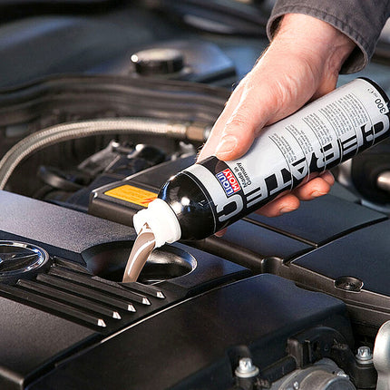 Liqui Moly Cera Tec being poured into the oil filler neck of a Mercedes engine