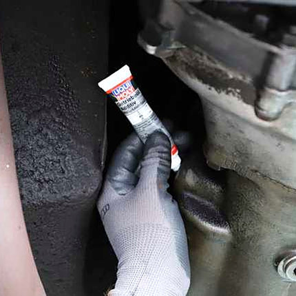 Liqui Moly Gear Oil Additive MoS2 tube being emptied into a manual gearbox filler