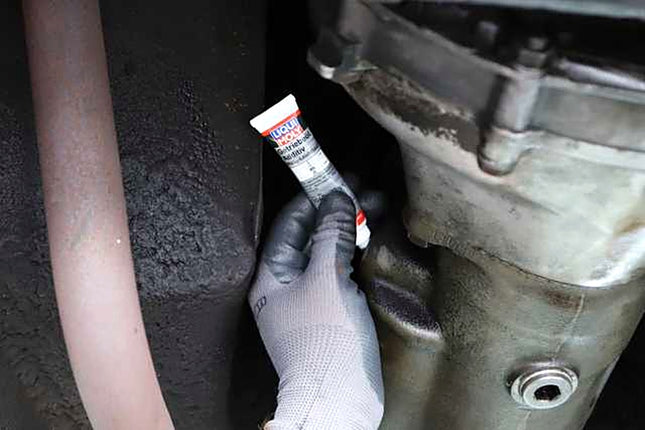 Liqui Moly Gear Oil Additive MoS2 tube being emptied into a manual gearbox filler