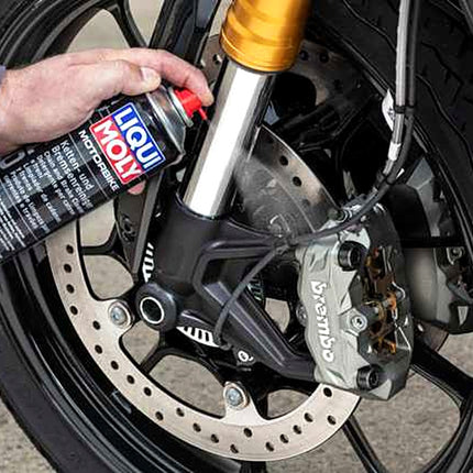 Liqui Moly Motorbike Chain and Brake Cleaner being sprayed onto a motorcycle brake disc