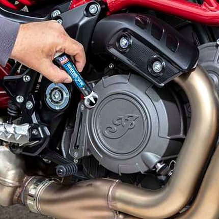 Liqui Moly Motorbike MoS2 Shooter tube being emptied into a motorcycle engine oil filler