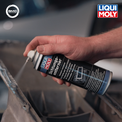 Person holding a LIQUI MOLY spray can near a car part with visible brand logos.